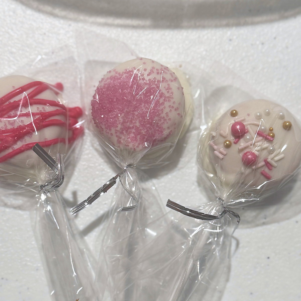 Pink and gold cake pops, wrapped and tied